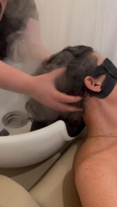 a person receiving a scalp massage during a scalp treatment